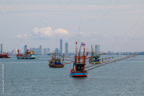 Fishing boats in the sea with the city background in Pattaya district,Chonburi province ,Thailand.