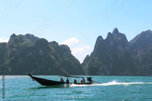 touri exploring on a long tail boat with beautiful landscape,mountains ,lake,blue sky and natural attractions from a long tail boat in Ratchaprapha Dam at Khao Sok National Park,Suratthani ,Thailand 