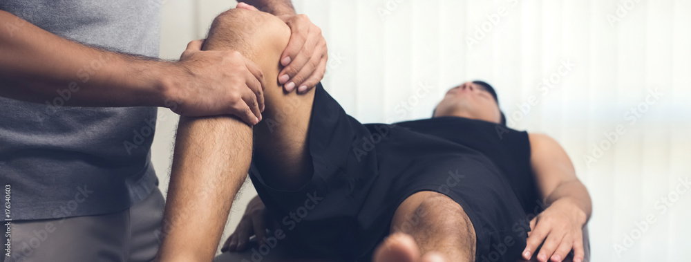 Asian male therapist giving massage to lower back pain patient in clinic  Stock Photo | Adobe Stock