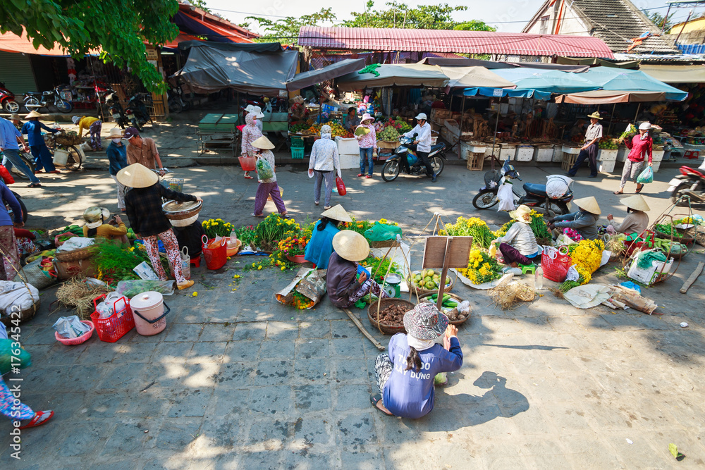 Flower vendors and food vendors selling products at Hoi An market in Hoi An Ancient Town. Hoi An is recognized as a World Heritage Site by UNESCO