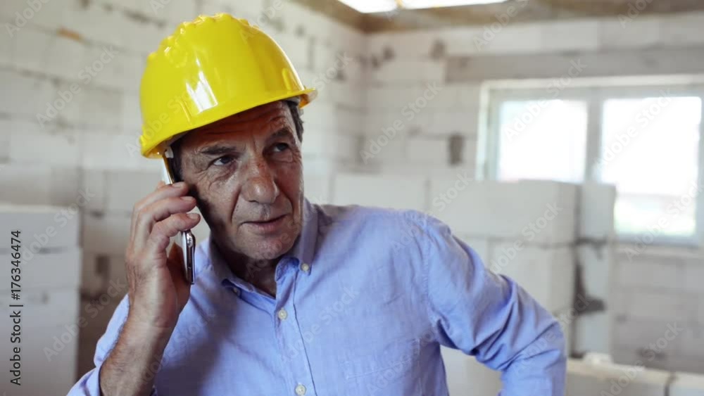 Senior architect with smartphone at the construction site. Senior architect with smartphone at the construction site.