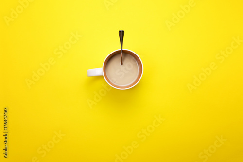 A Cup with coffee and spoon on a colored background. The concept of coffee breaks