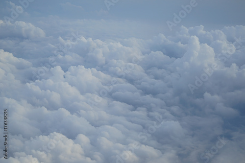 Shades of light blue color sky and floating white cloud wonderland view from airplane window