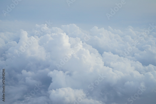Shades of light blue color sky and fluffy soft white cloud view from airplane window