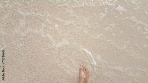 Vacation concept. Female legs walking by the sandy beach on clear sea waves line. View from the eyes, 4k UtraHD video. 