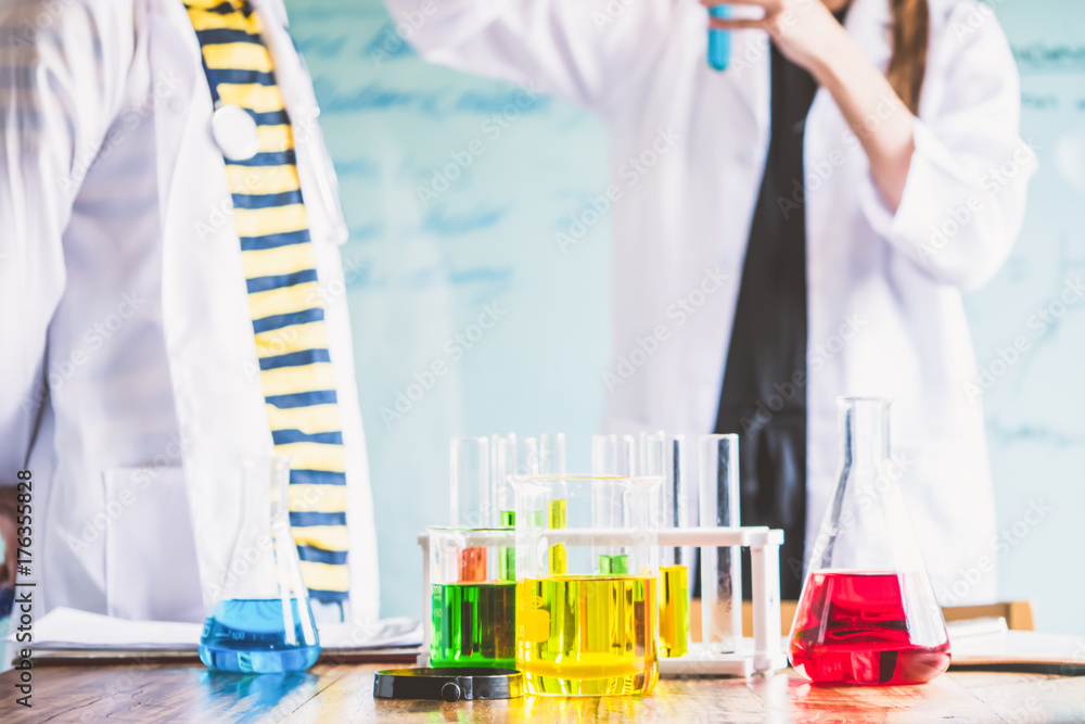 Couple of students working at chemistry class. Education concept Couple of students working at chemistry class. Education concept