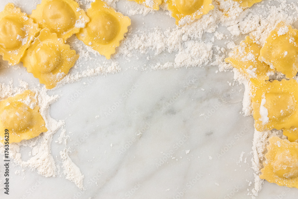Obraz premium Overhead photo of ravioli with flour and copy space