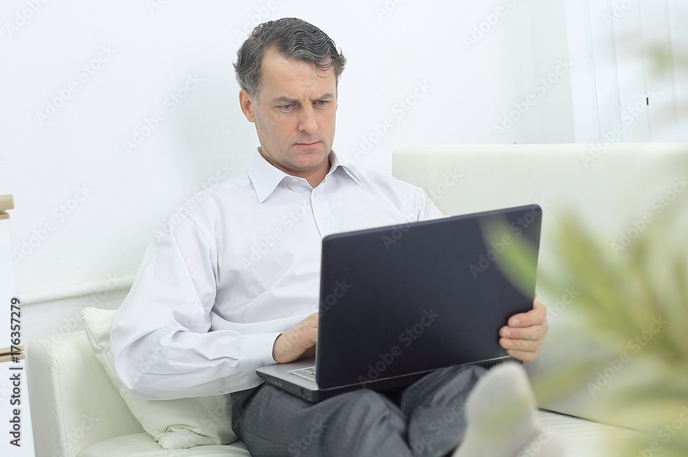 businessman working on laptop while sitting in a hotel room businessman working on laptop while sitting in a hotel room