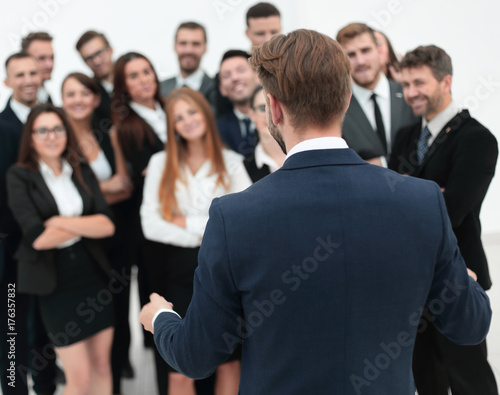 businessman makes a speech to his large business team