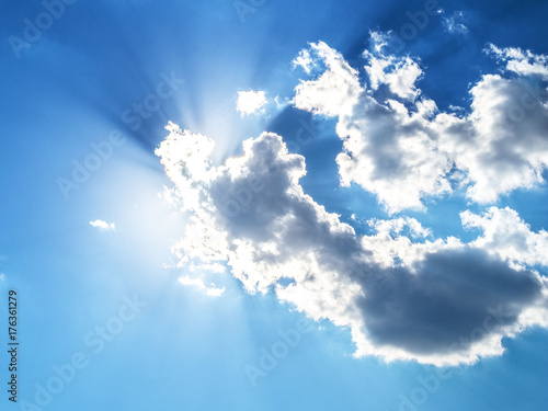 Blue sky with clouds and sun rays. Dramatic clouds.