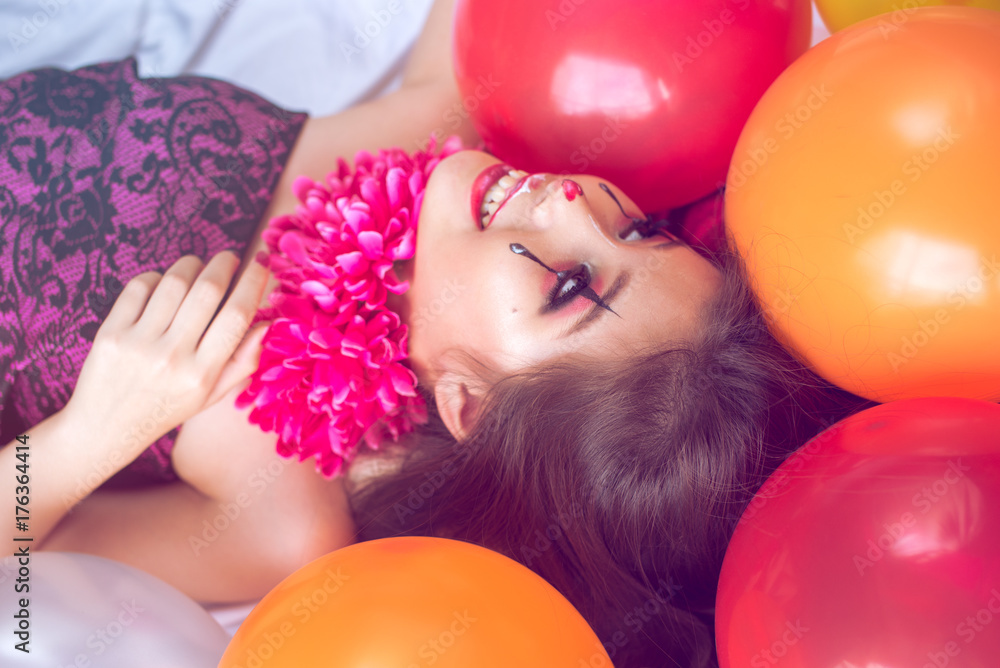 Happy teen girl lying between colorful balloons. Party Happy teen girl lying between colorful balloons. Party