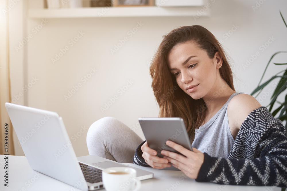 Student using tablet and sitting in study room Student using tablet and sitting in study room