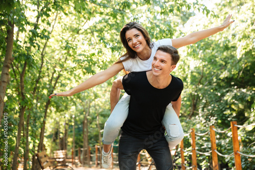 Foto Young smiling couple enjoying piggyback ride and laughing