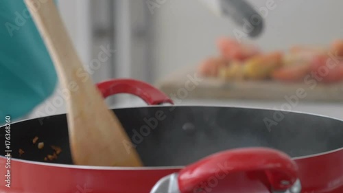 Woman mixing ingredients on frying pan and chopping tomatoes, steadycam shot
