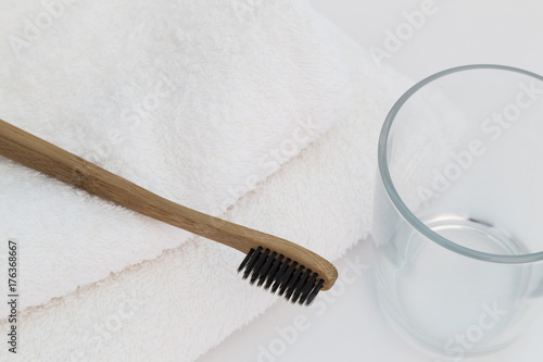 Wooden toothbrush with white towel and glass