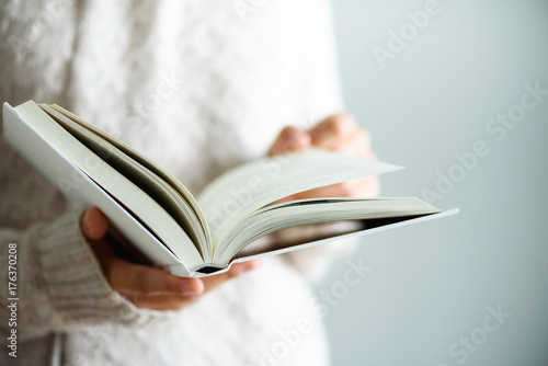 Young girl in white T-shirt reading opened book. Copy space. lifestyle and school concept photo