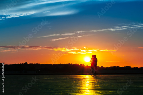 Couple hugging against the backdrop of the setting sun