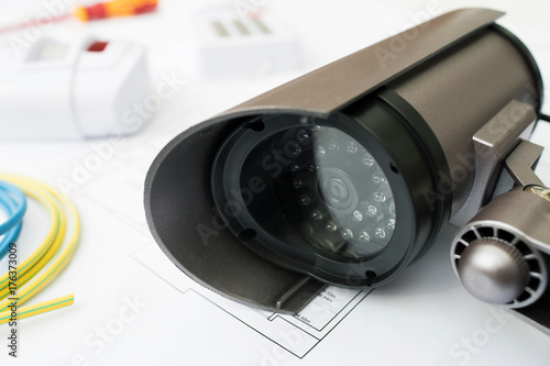 Still Life Of Home Security Products Arranged On House Plans