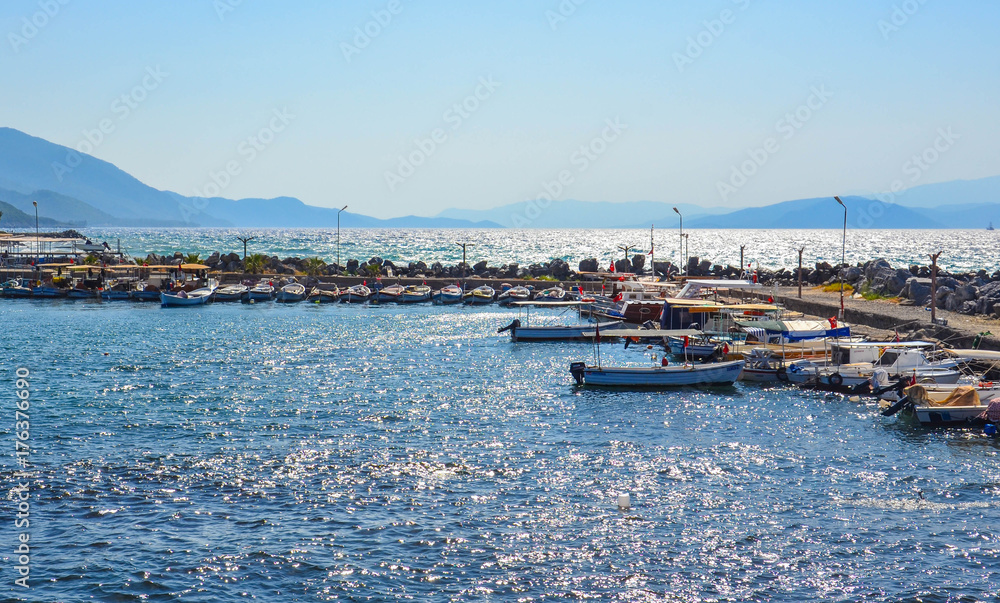 boats at the pier on the background of the sea and mountains