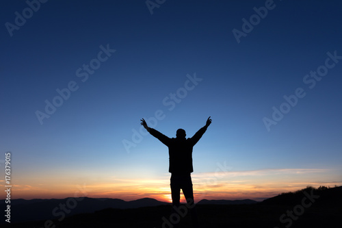 Victoire d'un homme au sommet d'une montagne au coucher de soleil