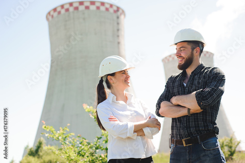 two workers wearing protective helmet works at electrical power station.