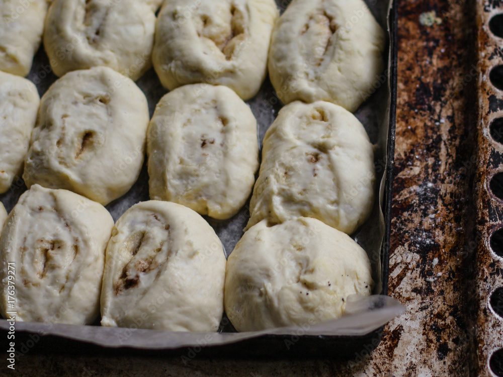 baking rolls with cinnamon - raw dough on a baking tray baking rolls with cinnamon - raw dough on a baking tray