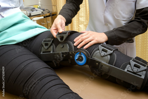 Physiotherapist adjust knee braces on patient 's leg,Rehabilitation for knee injury