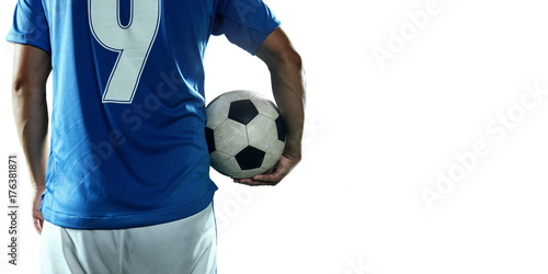 Soccer player holds a soccer ball on a professional stadium. Isolated football player in unbranded sport uniform on a white background.