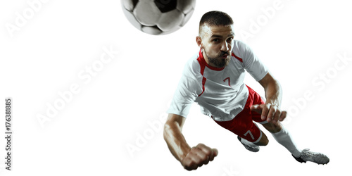 Soccer player performs an action play and beats the ball. Isolated football player in unbranded sport uniform on a white background. © Alex