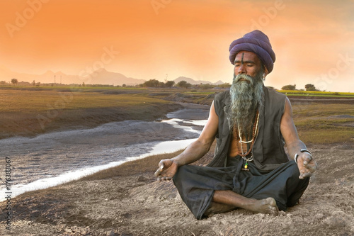 Sadhu meditation near river photo