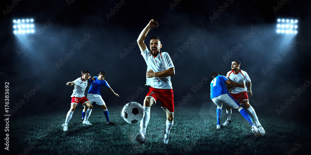 Soccer players performs an action play on a dark background. Soccer players fight for the ball. Players wears unbranded sport uniform.