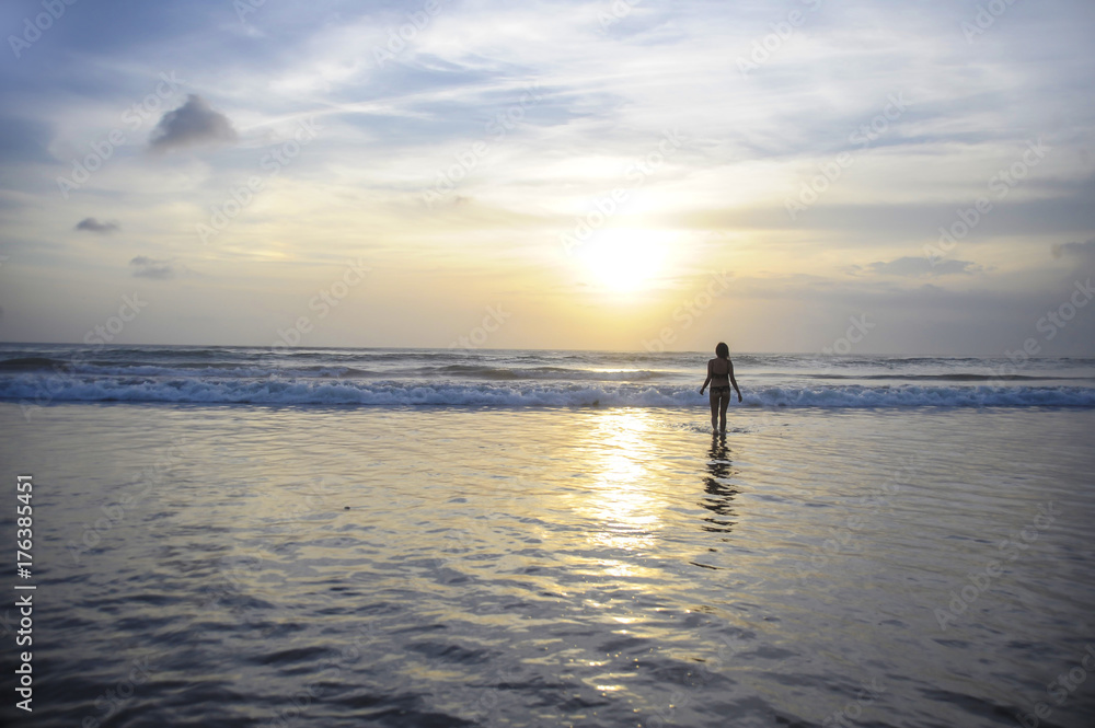 young active woman on sea landscape sunset horizon with amazing sun and dramatic orange sky