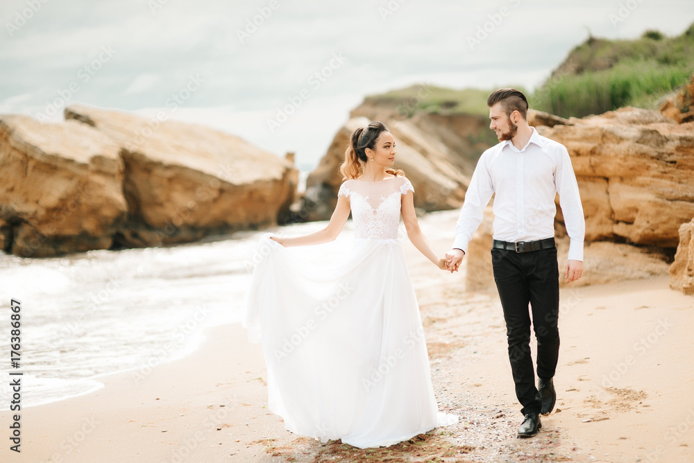 young couple groom with the bride on a sandy beach