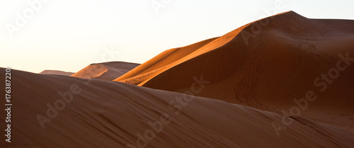 A game of shadows in the sand dunes of the desert at dawn