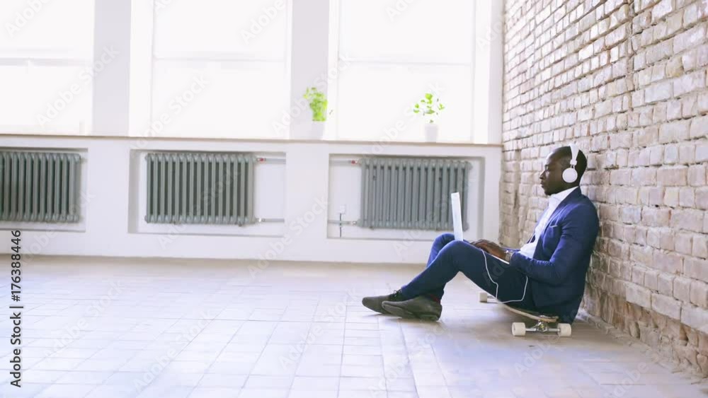 African businessman with laptop and headphones. African businessman with laptop and headphones.