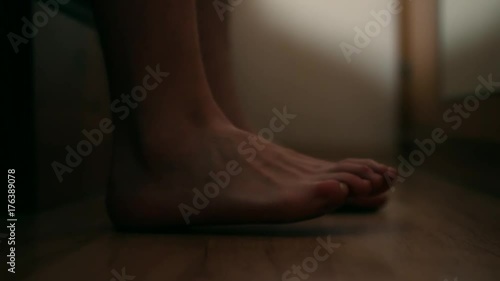 Male feet getting out of bed close up