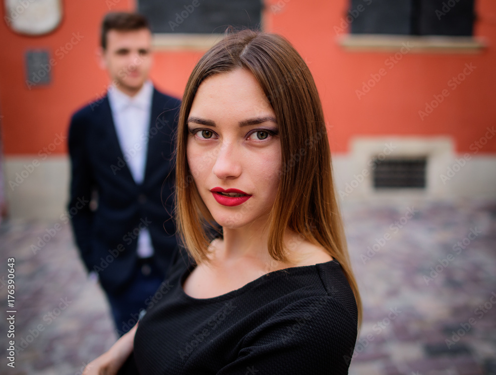 Man stands behind stunning woman with red lips Man stands behind stunning woman with red lips