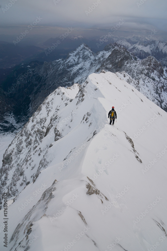 Bergsteiger klettert den Jubiläumsgrat im Winter bei Schnee von der Zugspitze zur Alpspitze