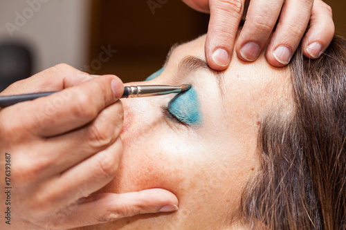 Make up artist applying eyeshadow to a woman