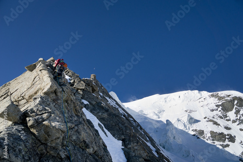 Bergsteiger klettert Felsgrat mit Seil und Sicherung im alpinen Fels auf den Piz Palü via Ostpfeiler, Kuffnerpfeiler  photo