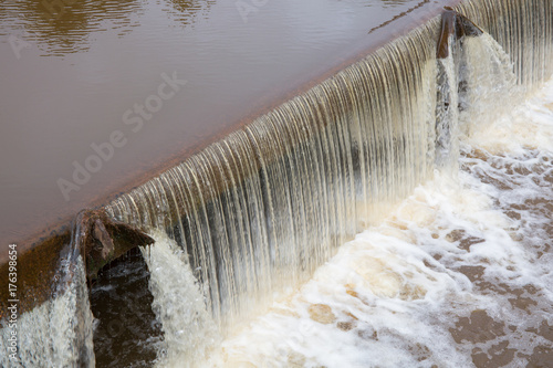 small waterfall on a river before a lock