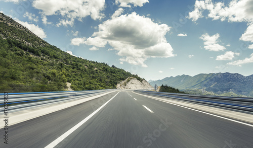 Obraz na plátne Highway outside the city receding into the highlands.