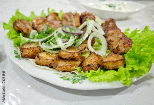 Barbecue beef with onion and salad on the plate. Oriental cuisine in Azerbaijan