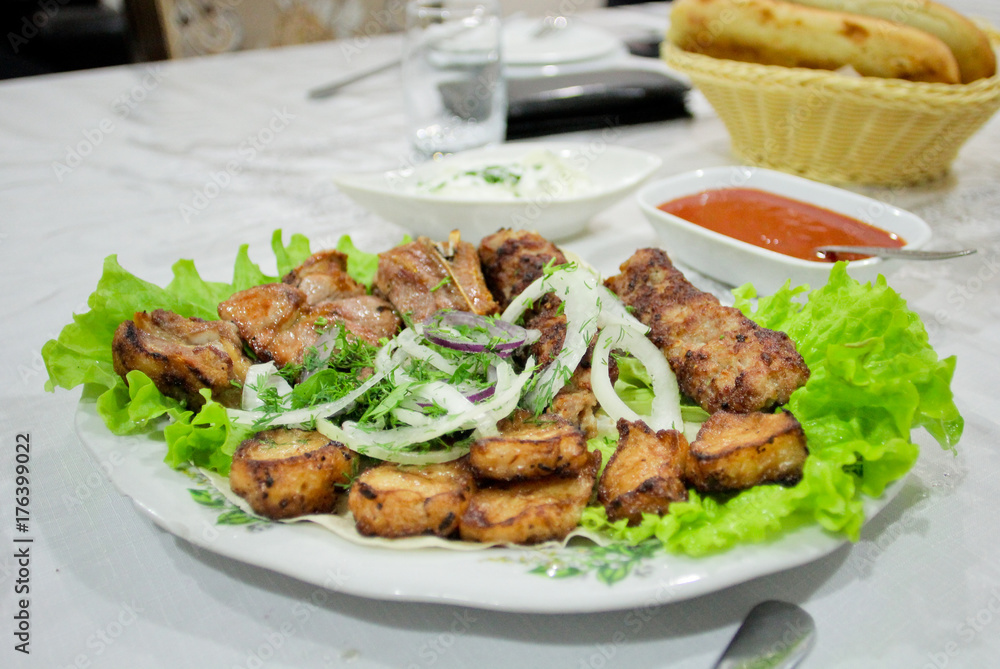 Barbecue beef with onion and salad on the plate. Oriental cuisine in Azerbaijan
