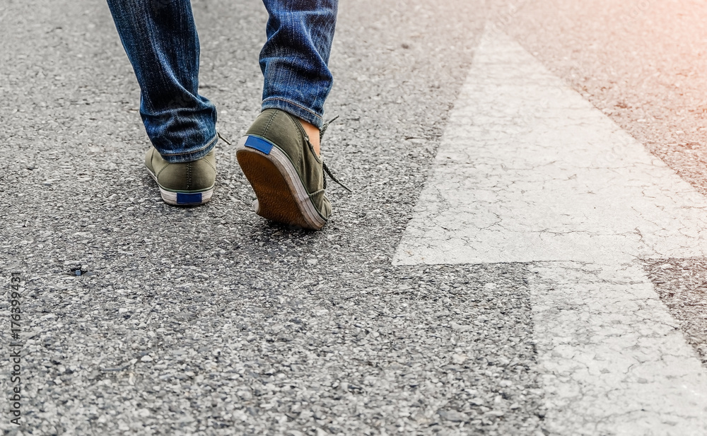 Woman wear jeans and sneaker shoes walk on the road Woman wear jeans and sneaker shoes walk on the road