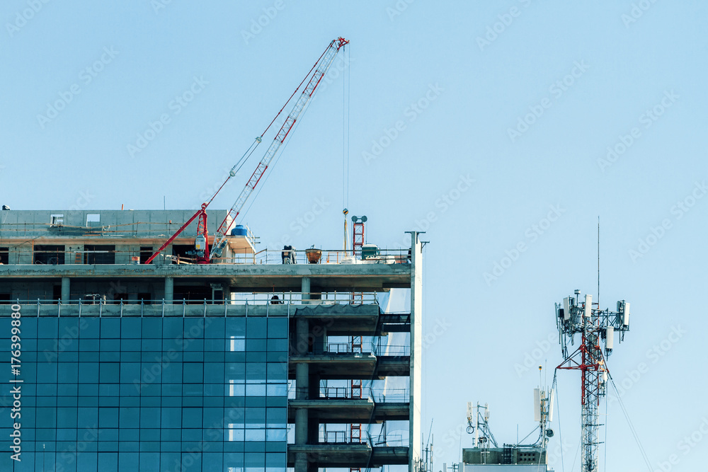 Building under construction with crane and telephone antenna Building under construction with crane and telephone antenna