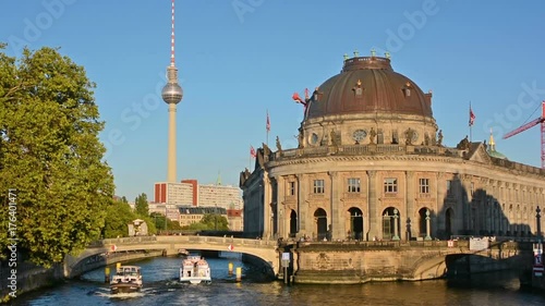 Boat cruises in front of the Bode Museum at sunset in Berlin.