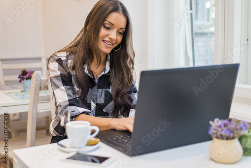 Woman working on her laptop in a cafe