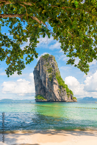 view of a rock in the sea from under the foliage of a tree on Poda Island, Thailand