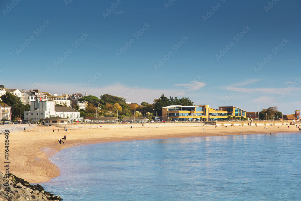 View of the coastal city of Exmouth. The city is in the mouth of the river Exe. On a beach in good weather people are walking - tourists and locals